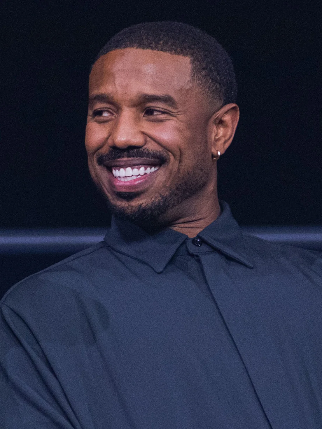 Michael B. Jordan sorrindo em evento; ele é um dos produtores executivos da série Quarta Asa
